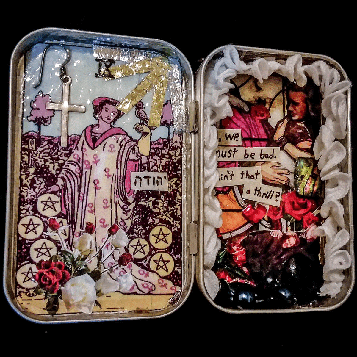 an altar inside an altoids tin. it has the Nine of Pentacles tarot card on one side, and a collage of images on the other depicting Judas Iscariot, and sometimes Jesus hugging him. There are also flowers, stones, and lace in the altar